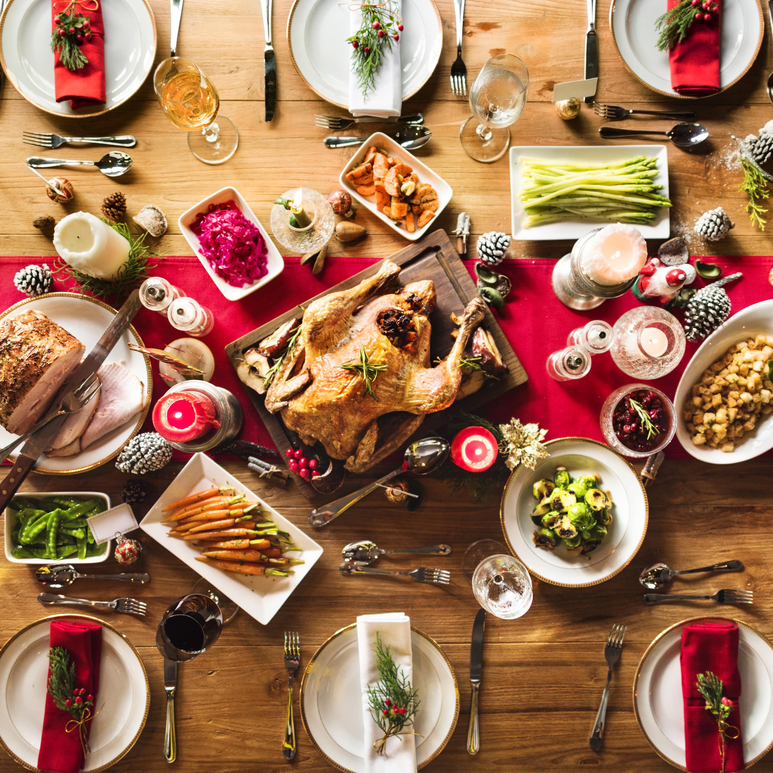 Une table de Noël avec une volaille entourée de légumes.