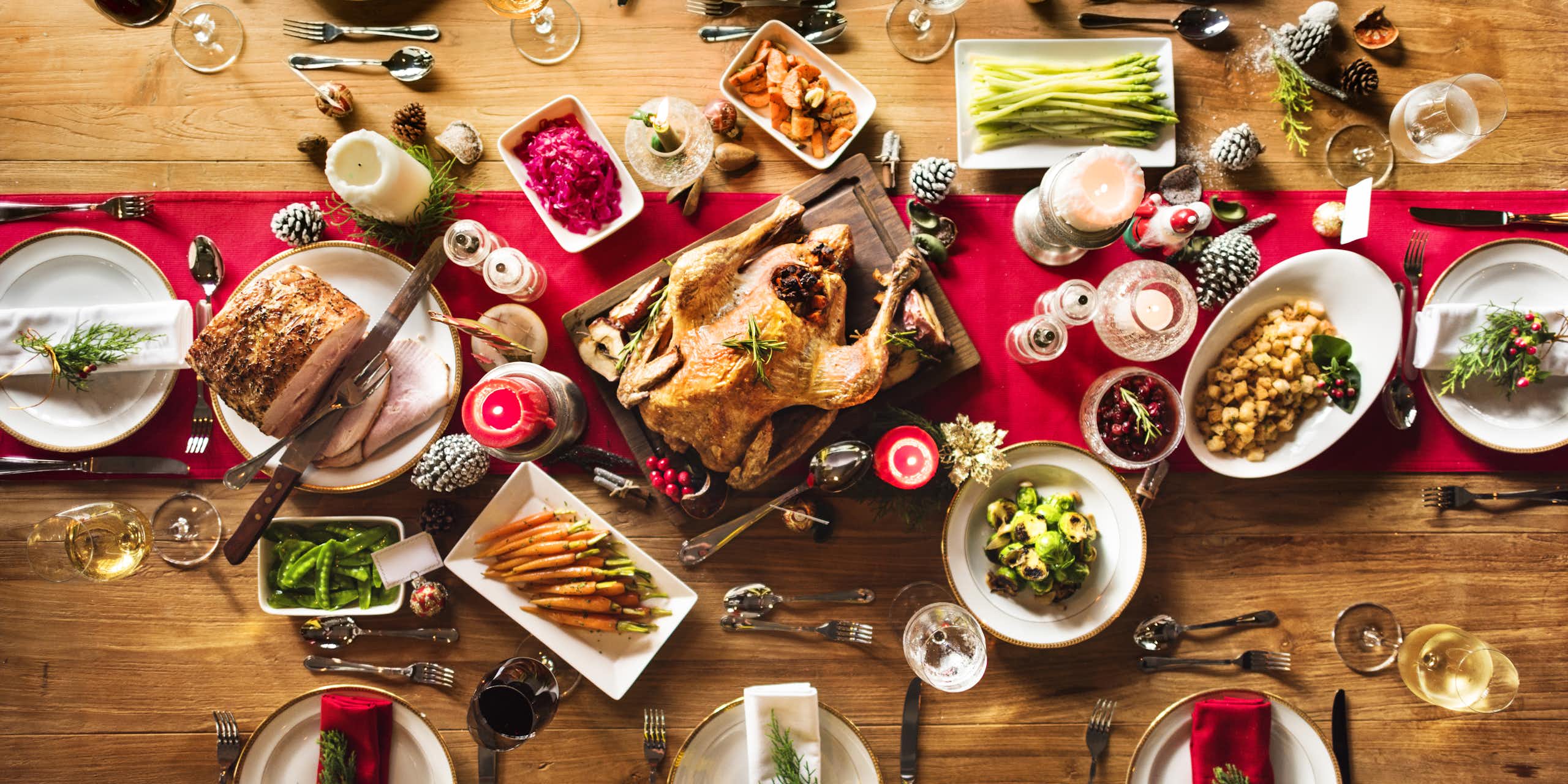 Une table de Noël avec une volaille entourée de légumes.