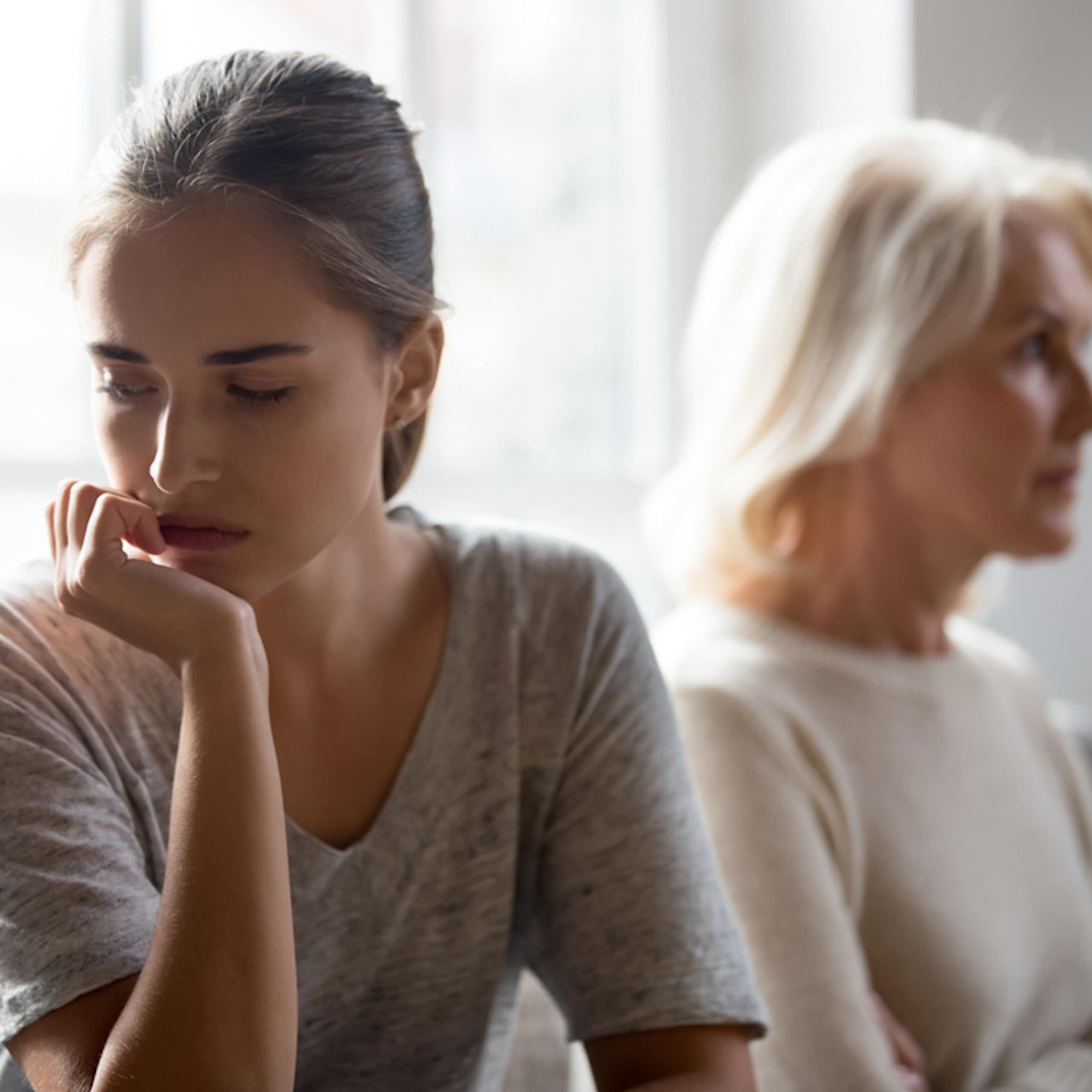 Une jeune femme pensive avec une femme d'âge mûre en arrière plan