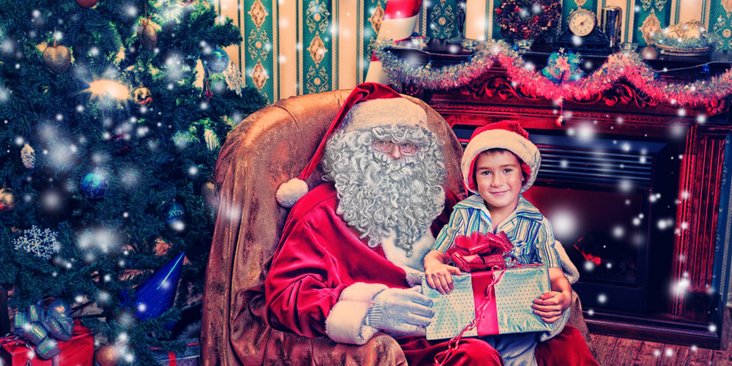 enfant assis sur les genoux d'un père noël, qui lui donne un cadeau