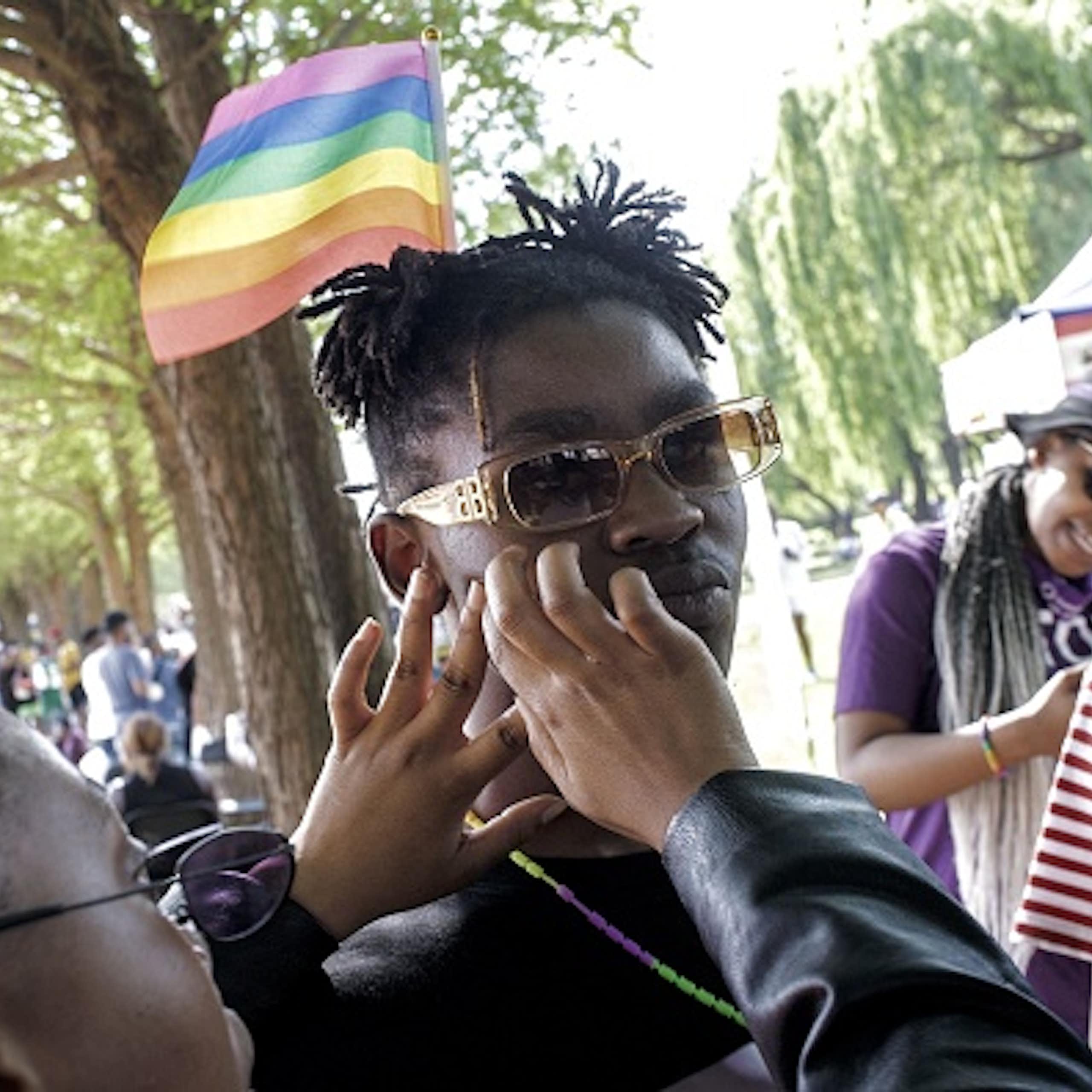 A rainbow flag is taped on the cheek of a member of the LGTBI community during the Soweto Pride in 2021.