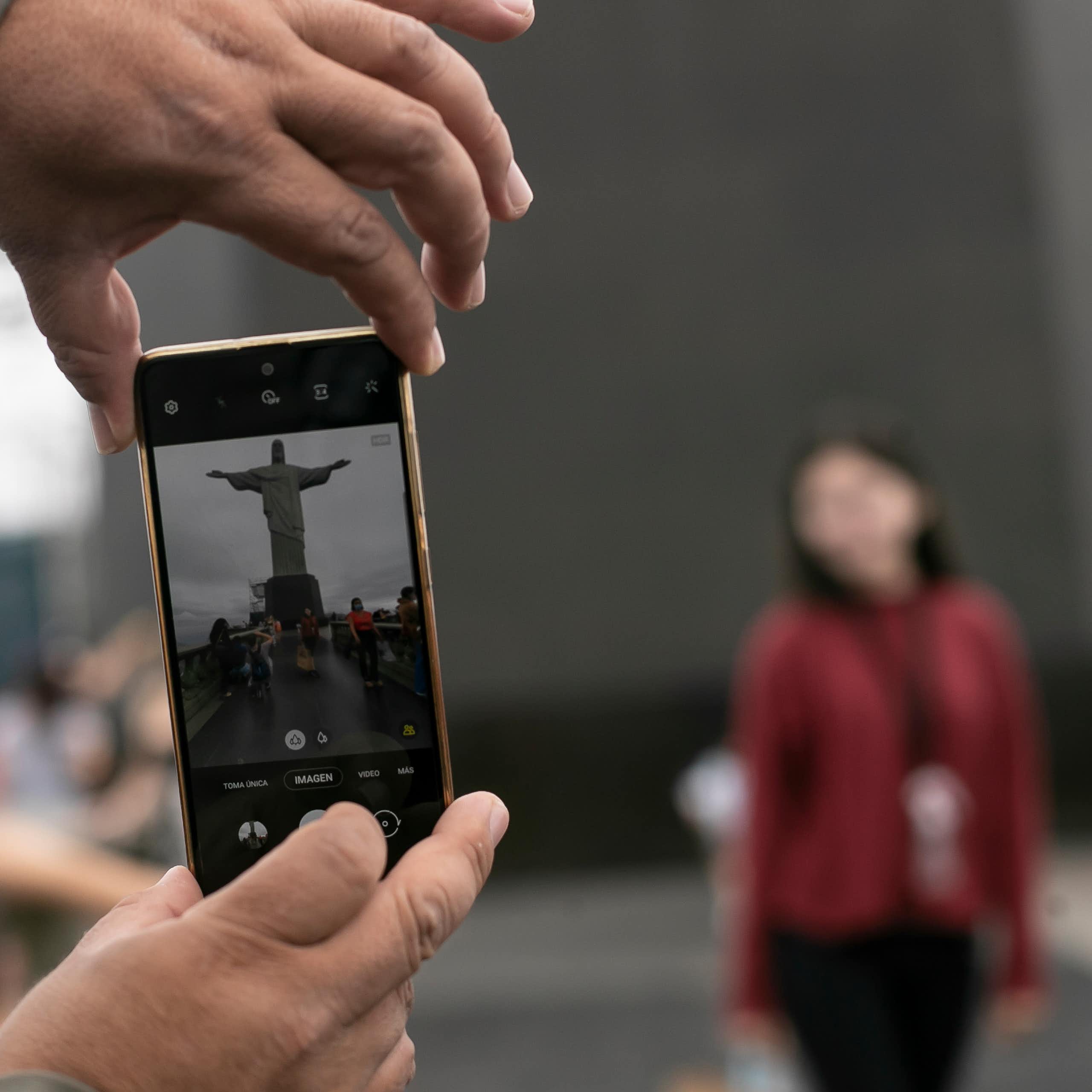 Christ the Redeemer being photographed from a mobile phone