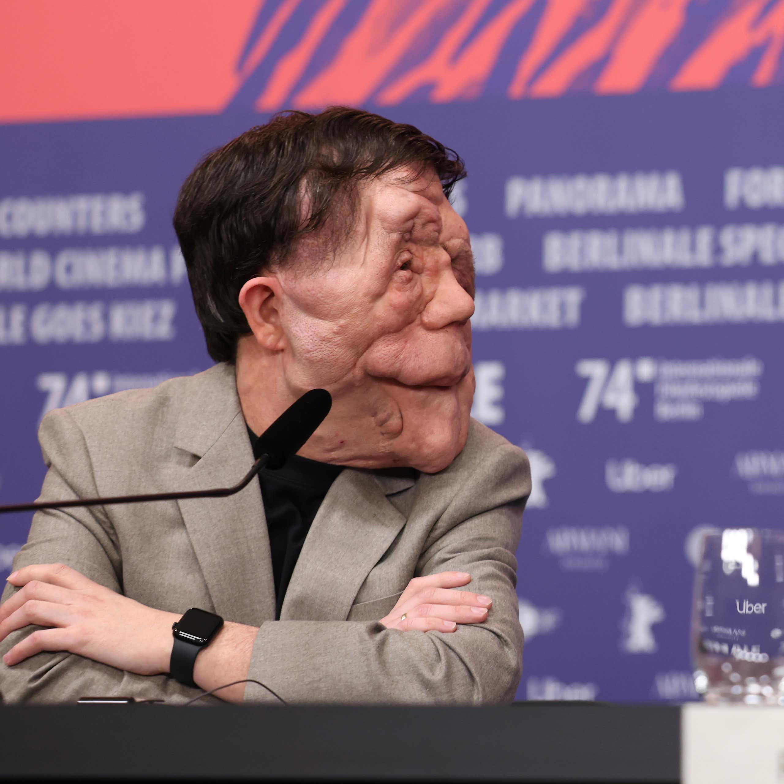 Two people sitting in dialogue at a press conference.