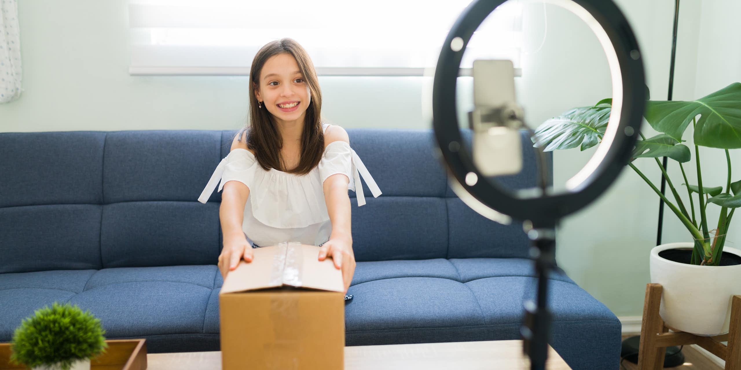 kid influencer recording herself opening a box