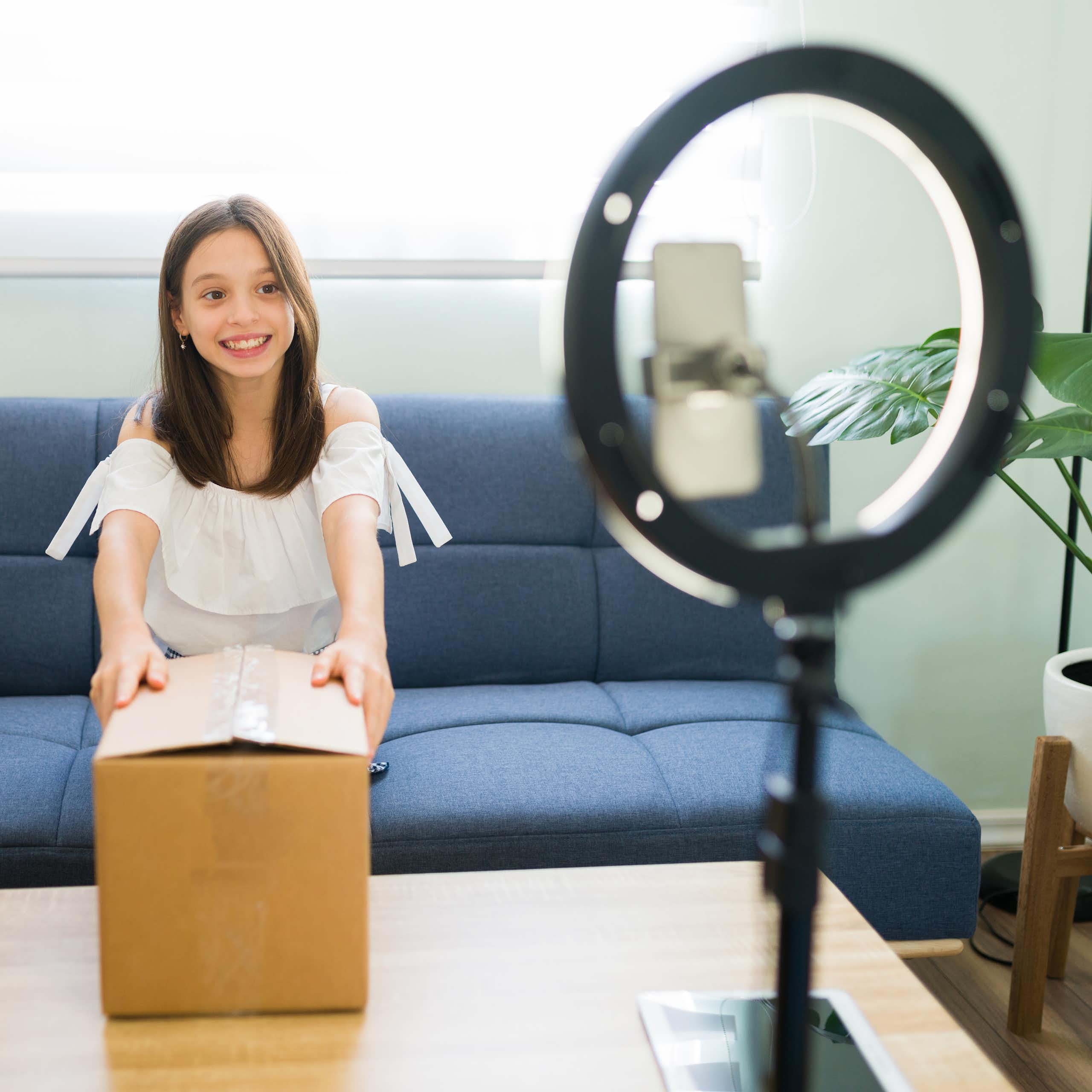 kid influencer recording herself opening a box