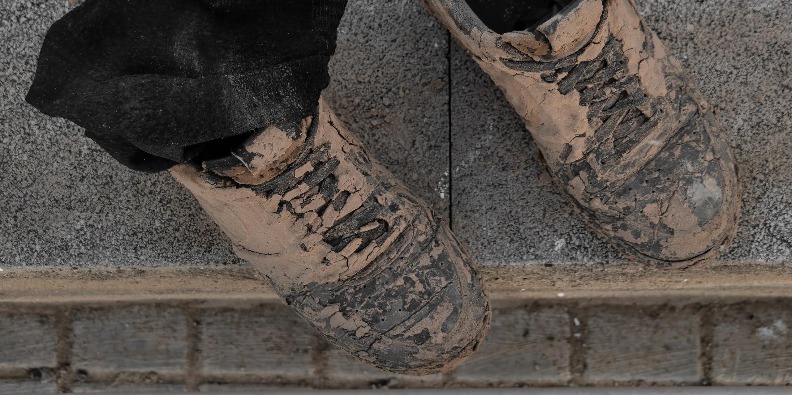 Dos botas completamente manchadas de barro.