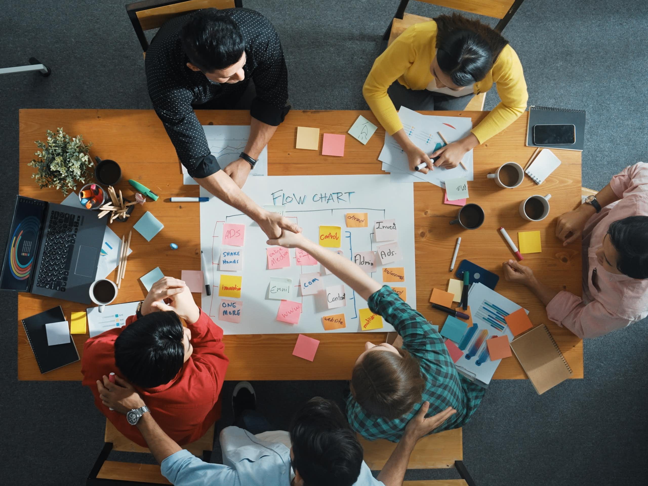 Overhead shot of a group of people sitting around and working at a conference table