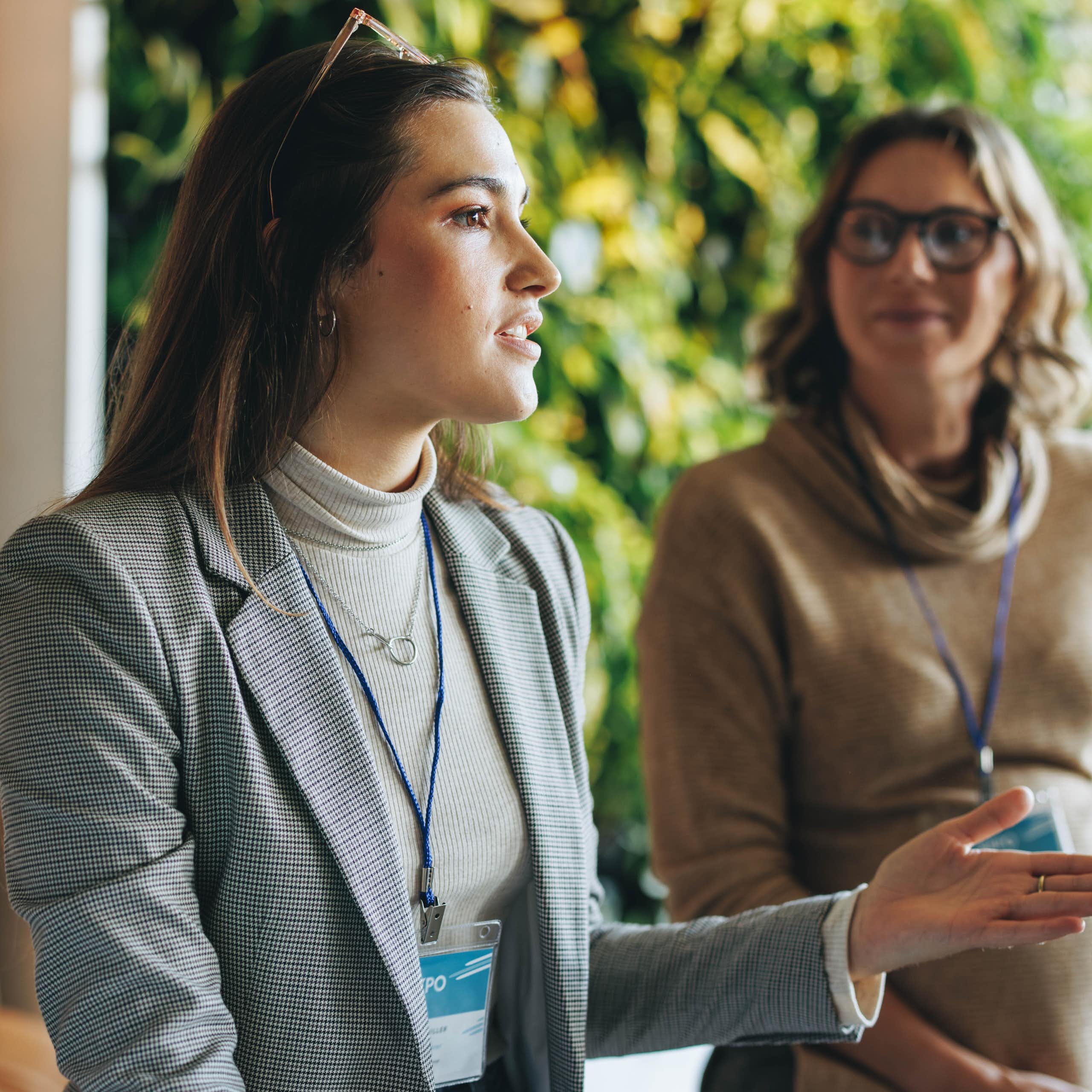 Three women wearing lanyards having a conversation