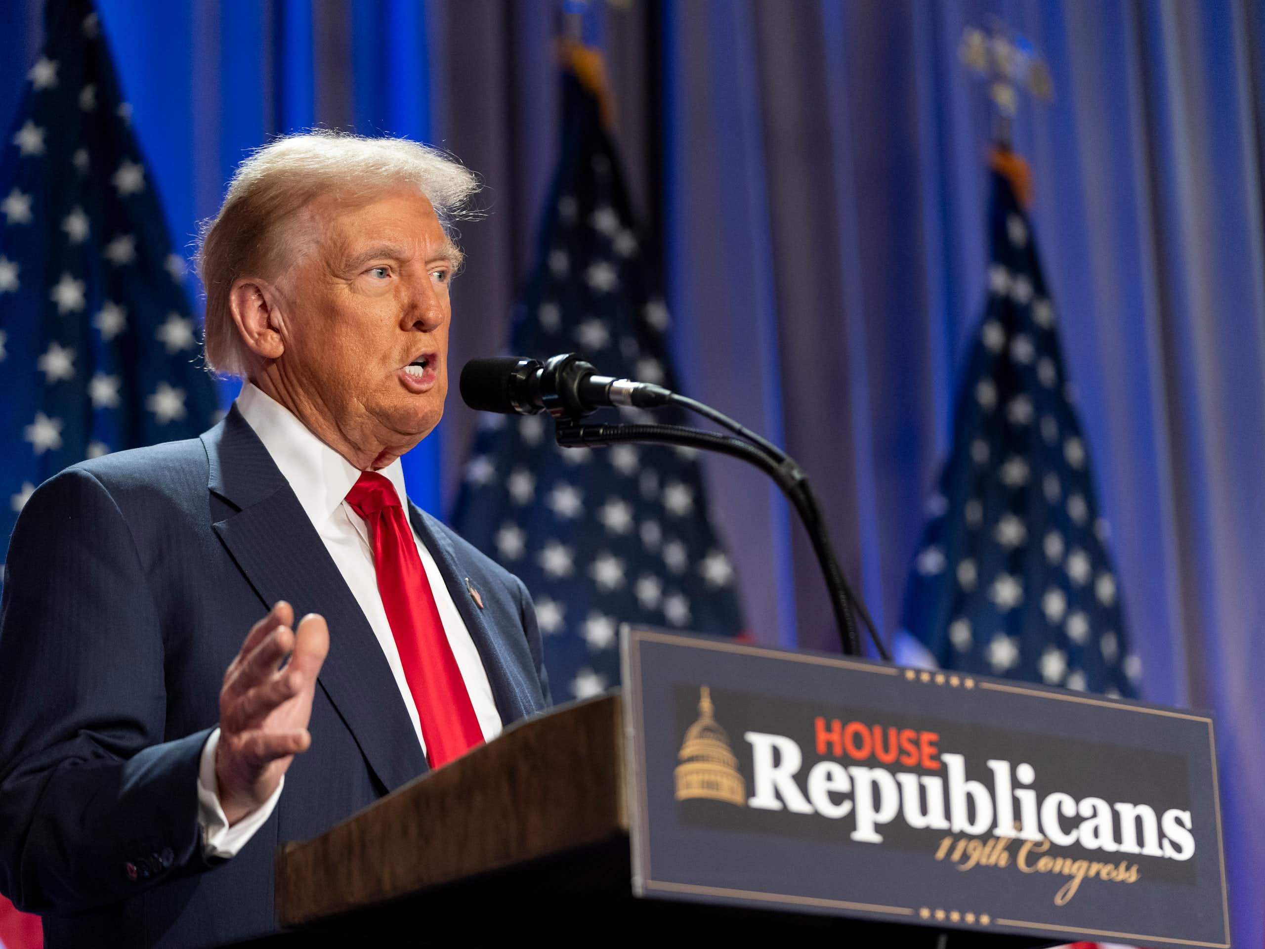 A man with orange-tinged skin in a suit speaks from behind a podium that says 'House Republicans 119th COngress'