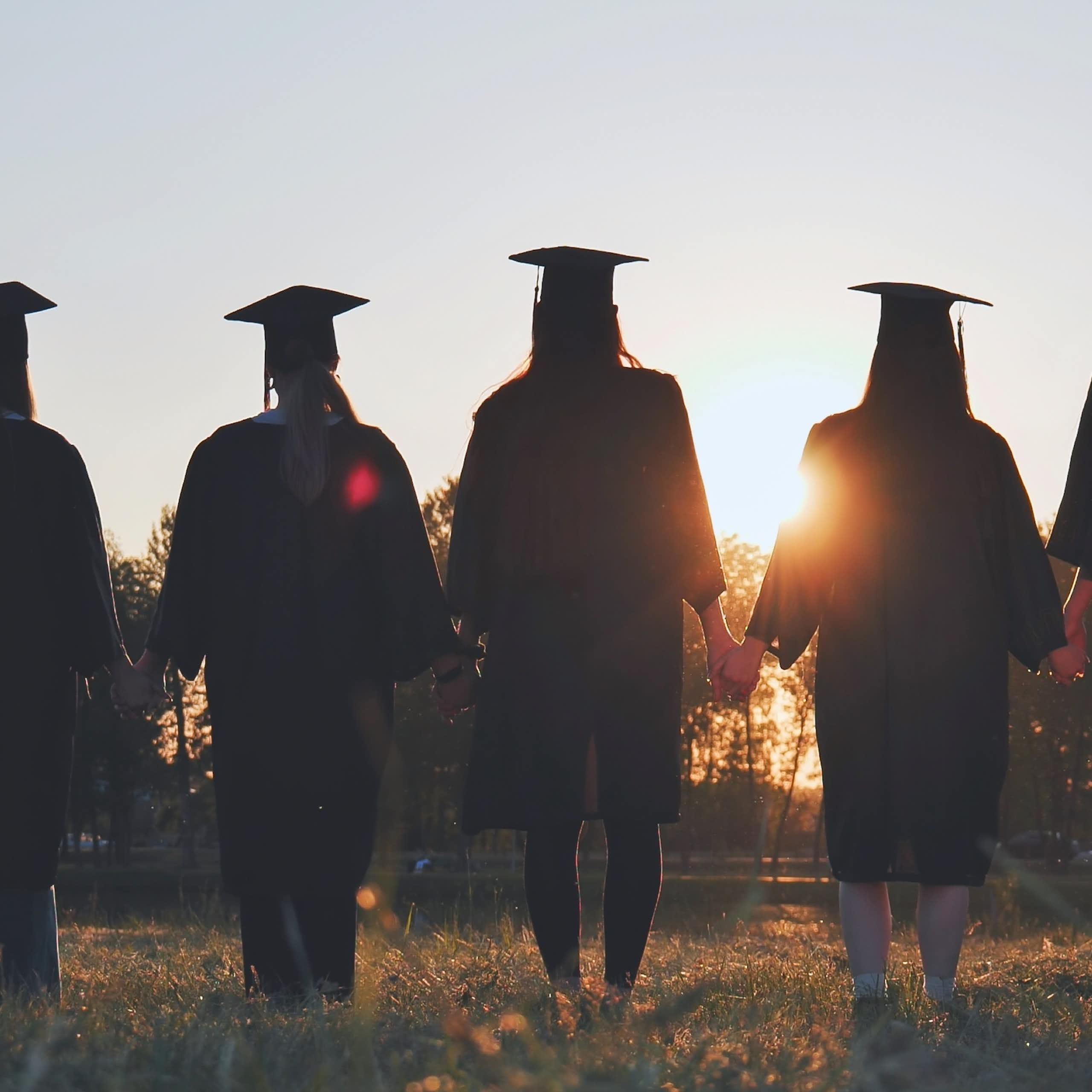 A group of graduates holding hands.