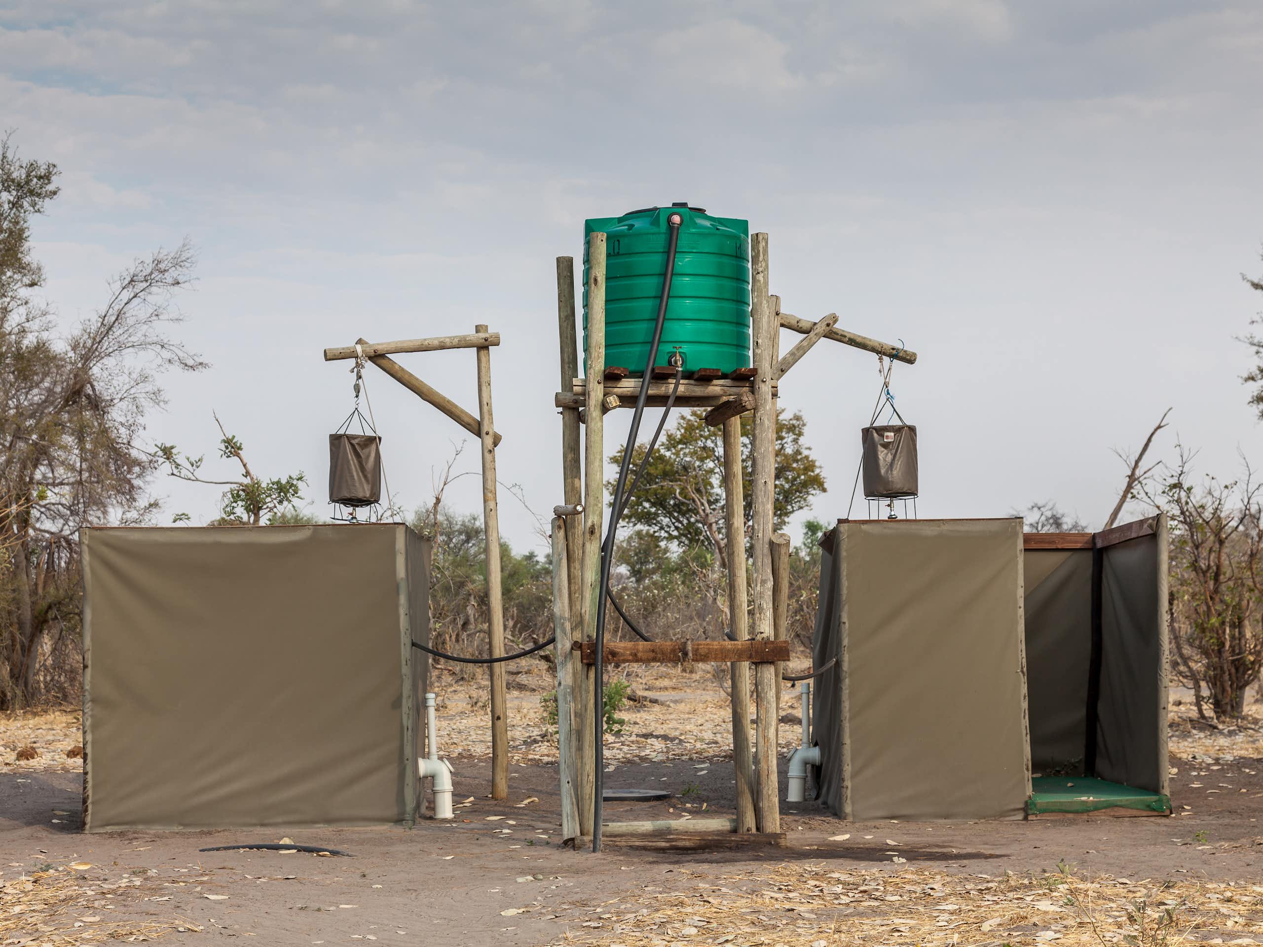 Eco-friendly outdoor showers with a bucket hung up high and linked to a water tank