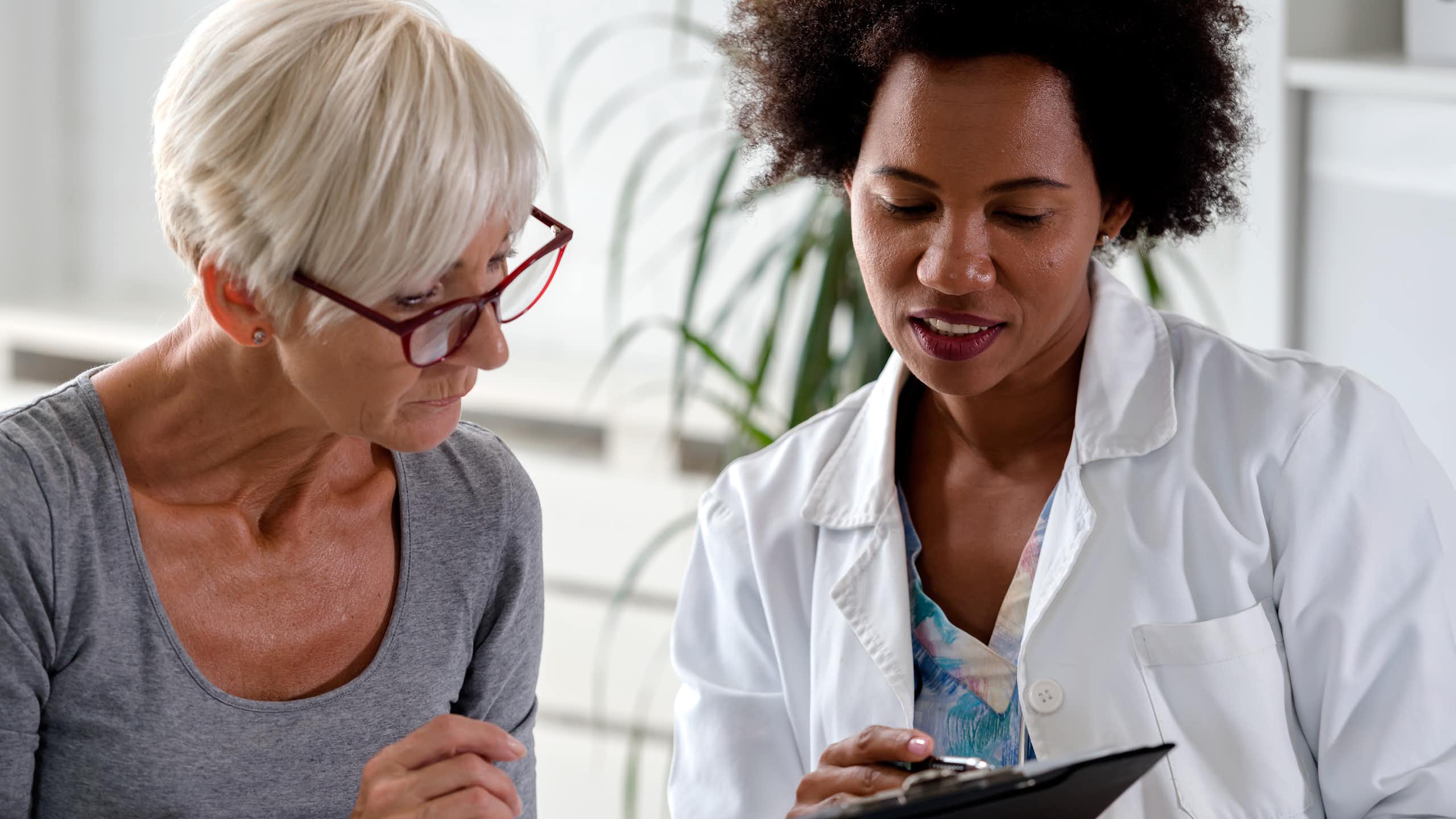 A woman with gray hair and a doctor in a white lab coat