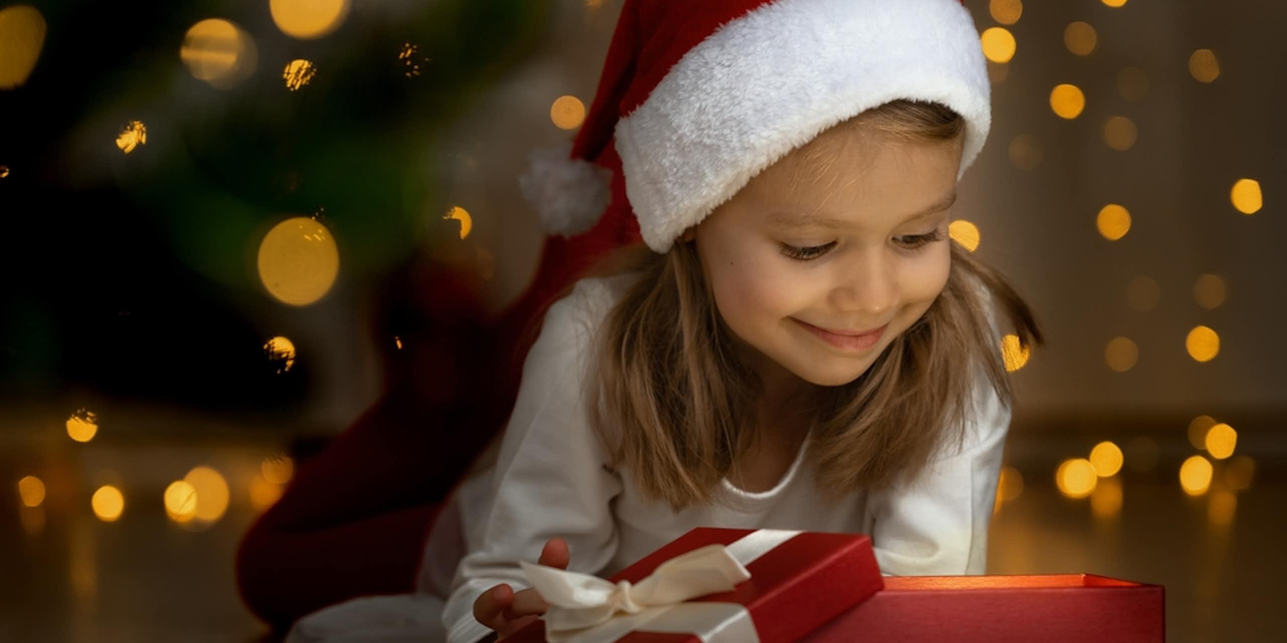 Une petite fille avec un bonnet de Père Noël.