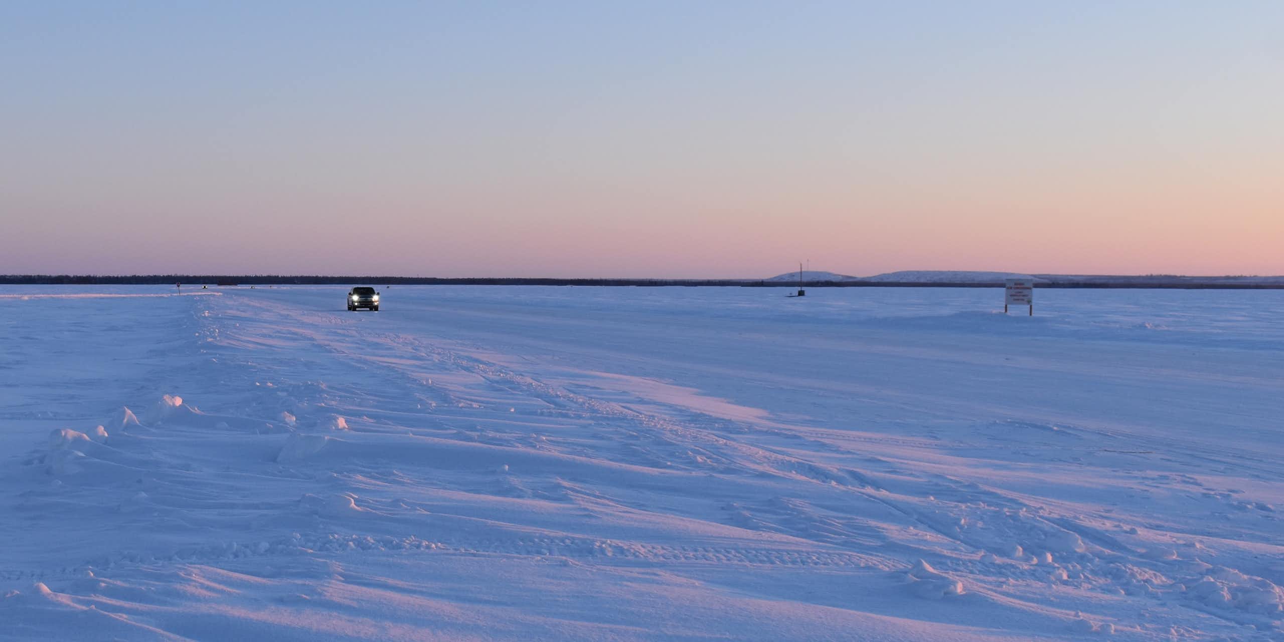 A car drives across an ice road.
