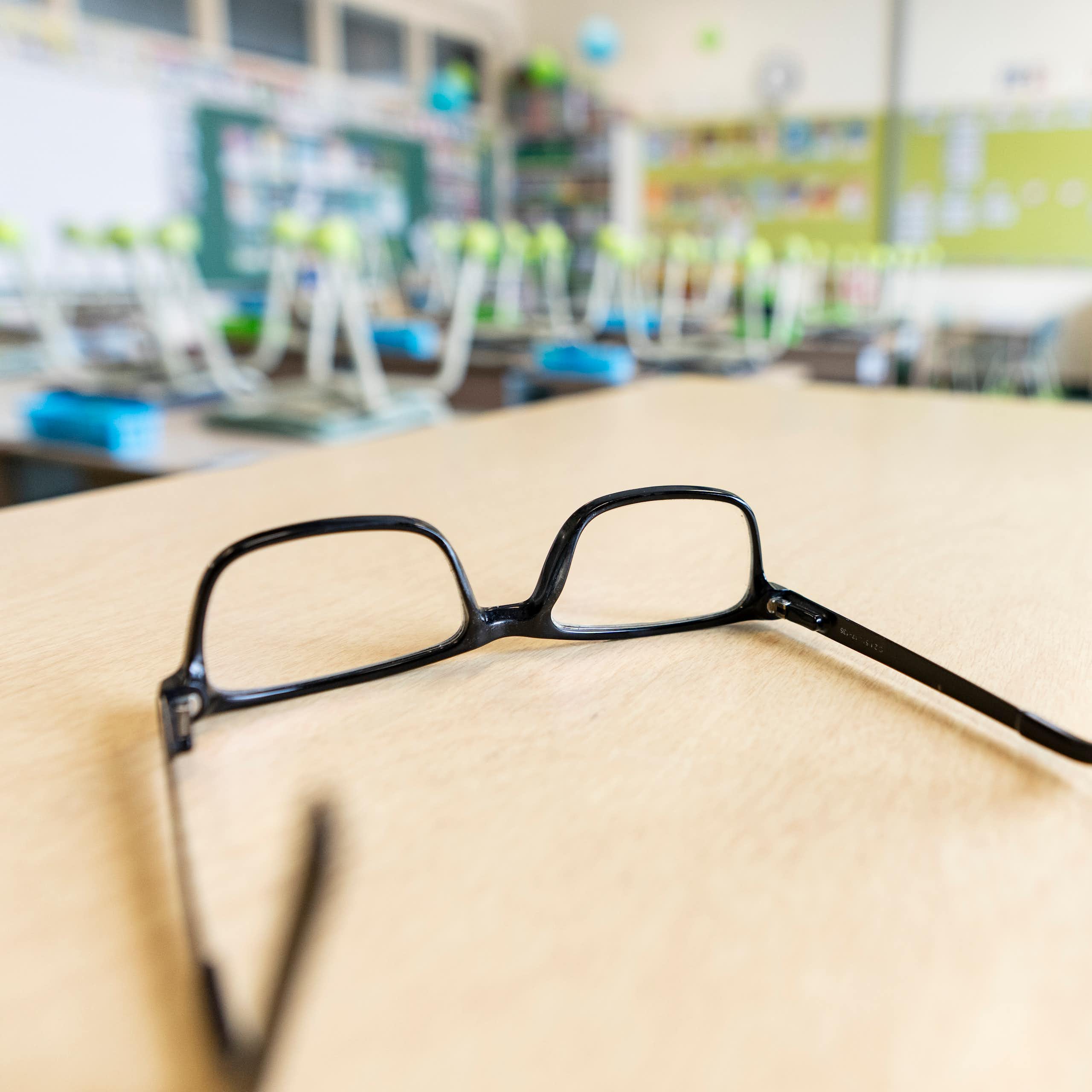 A pair of glasses upside down on a table.