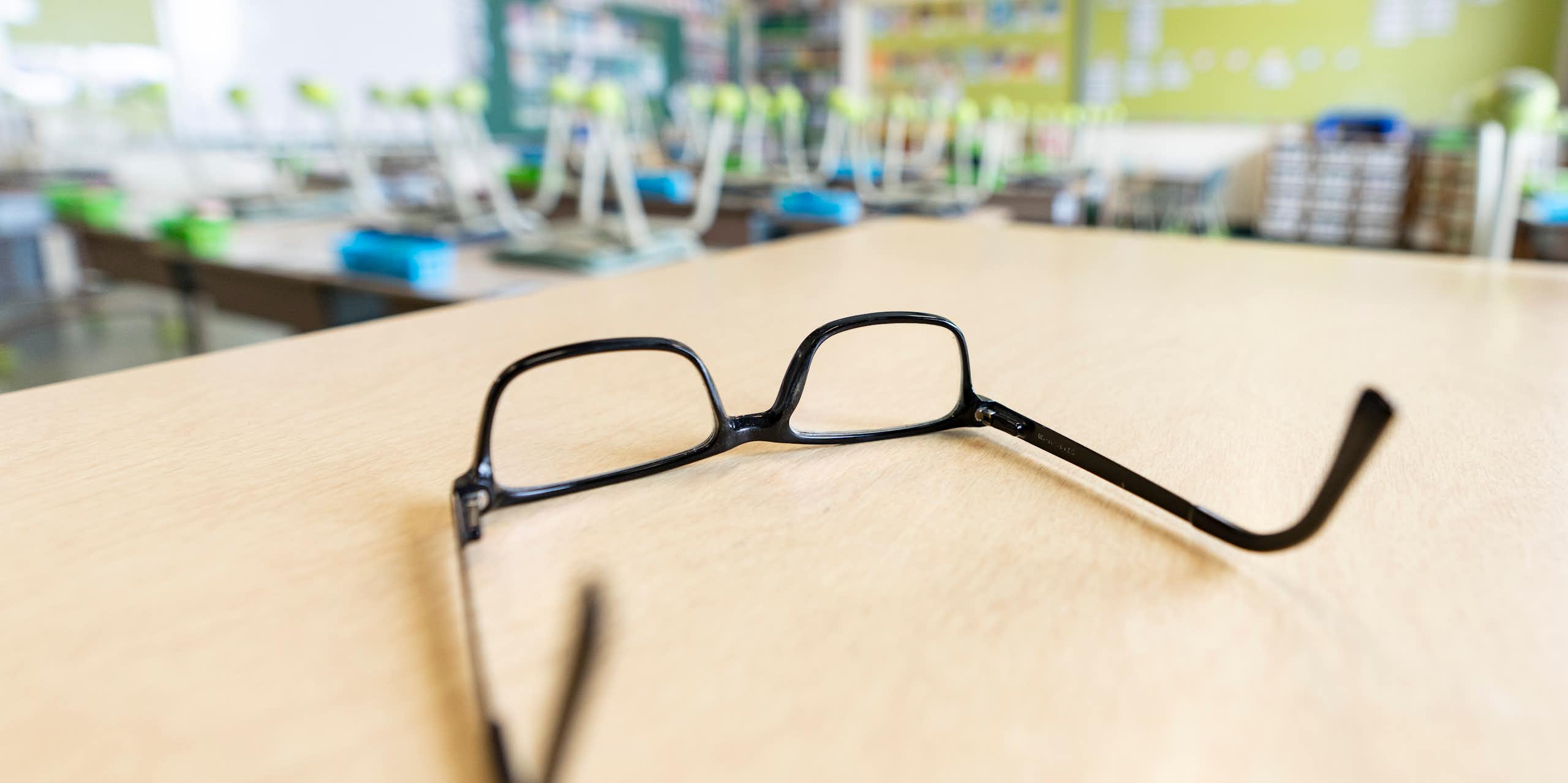A pair of glasses upside down on a table.