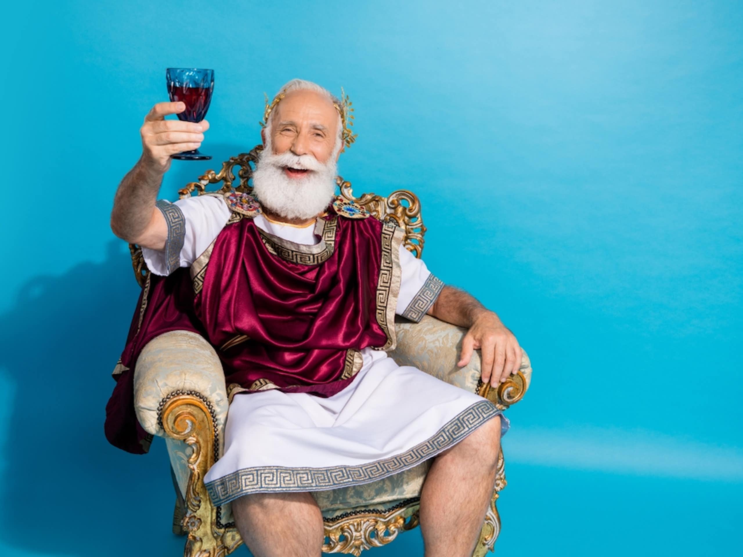 Ancient Greek or Roman sitting in chair, holding glass of red wine in hand, aloft