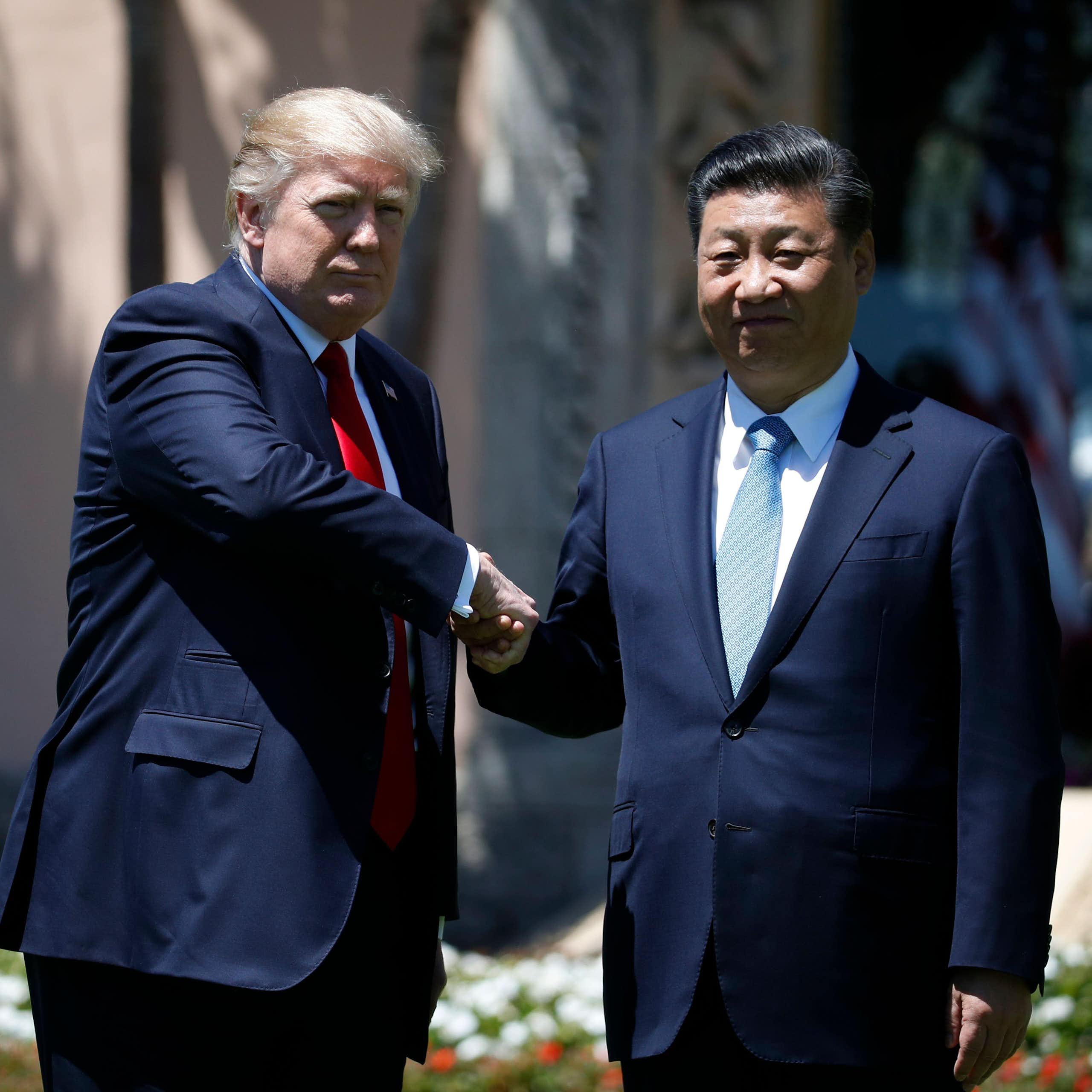 Donald Trump and Xi Jingping shake hands.
