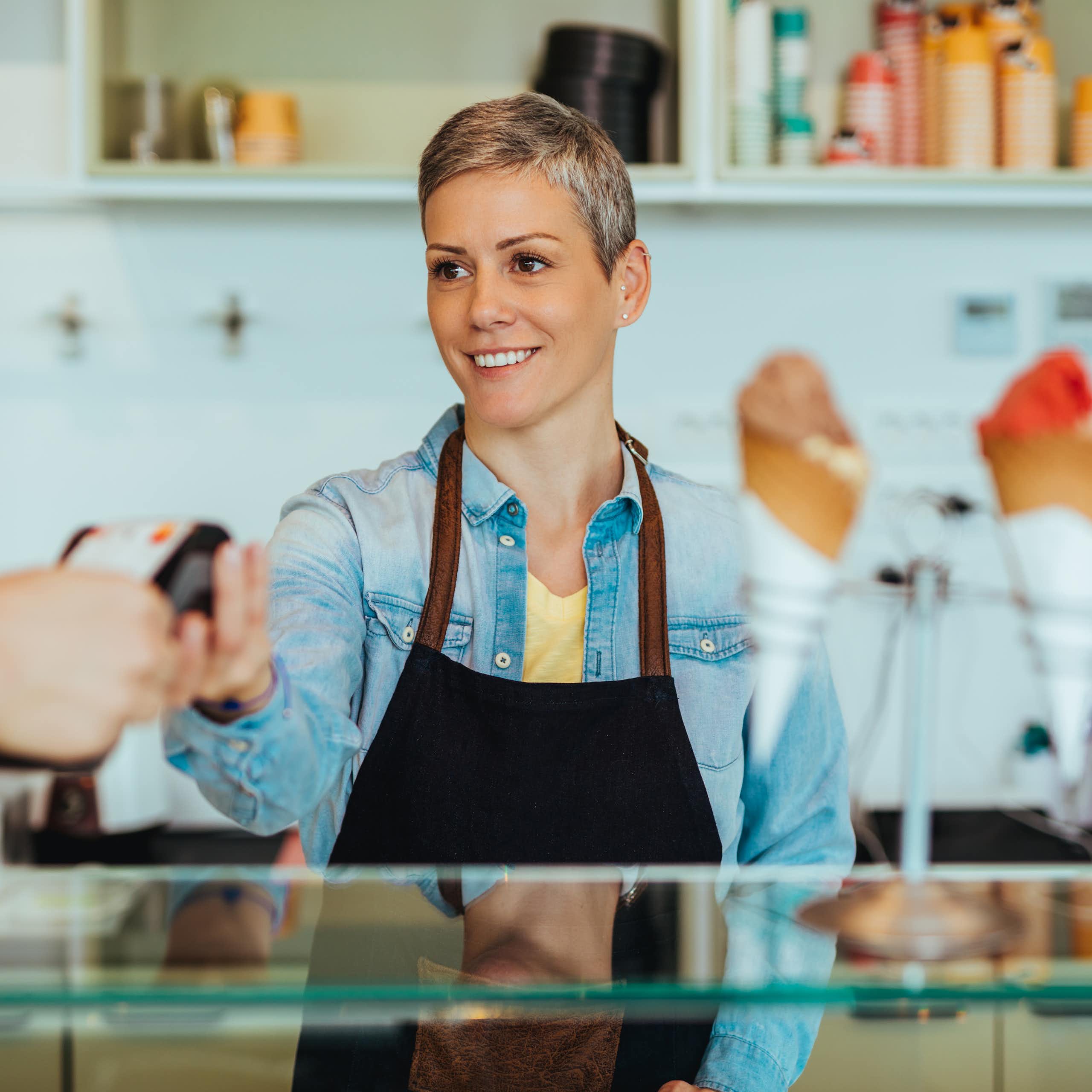 Woman standing behind a counter serving icecream