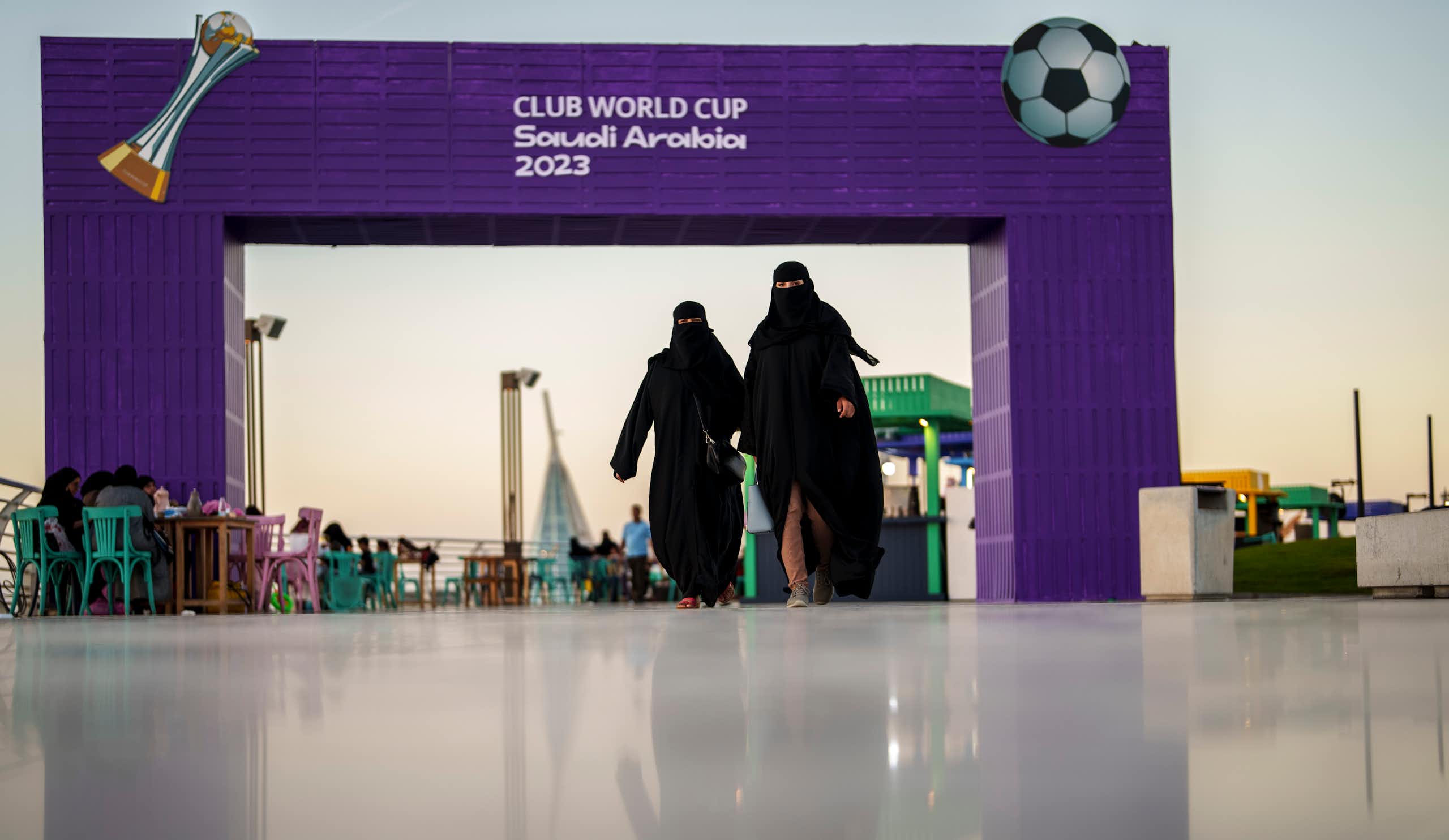 Women walk in front of a fan zone during the Soccer Club World Cup in Saudi Arabia, 2023.