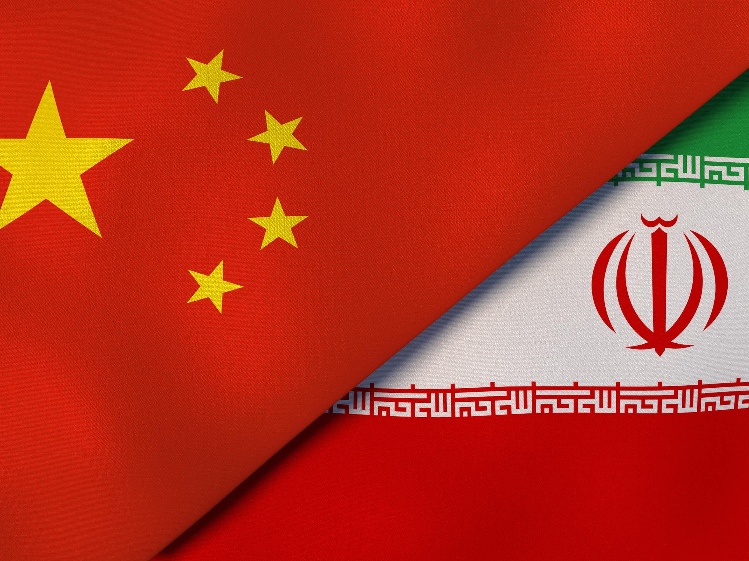 Two flags, one red with gold stars and another green, white and red, next to one another.