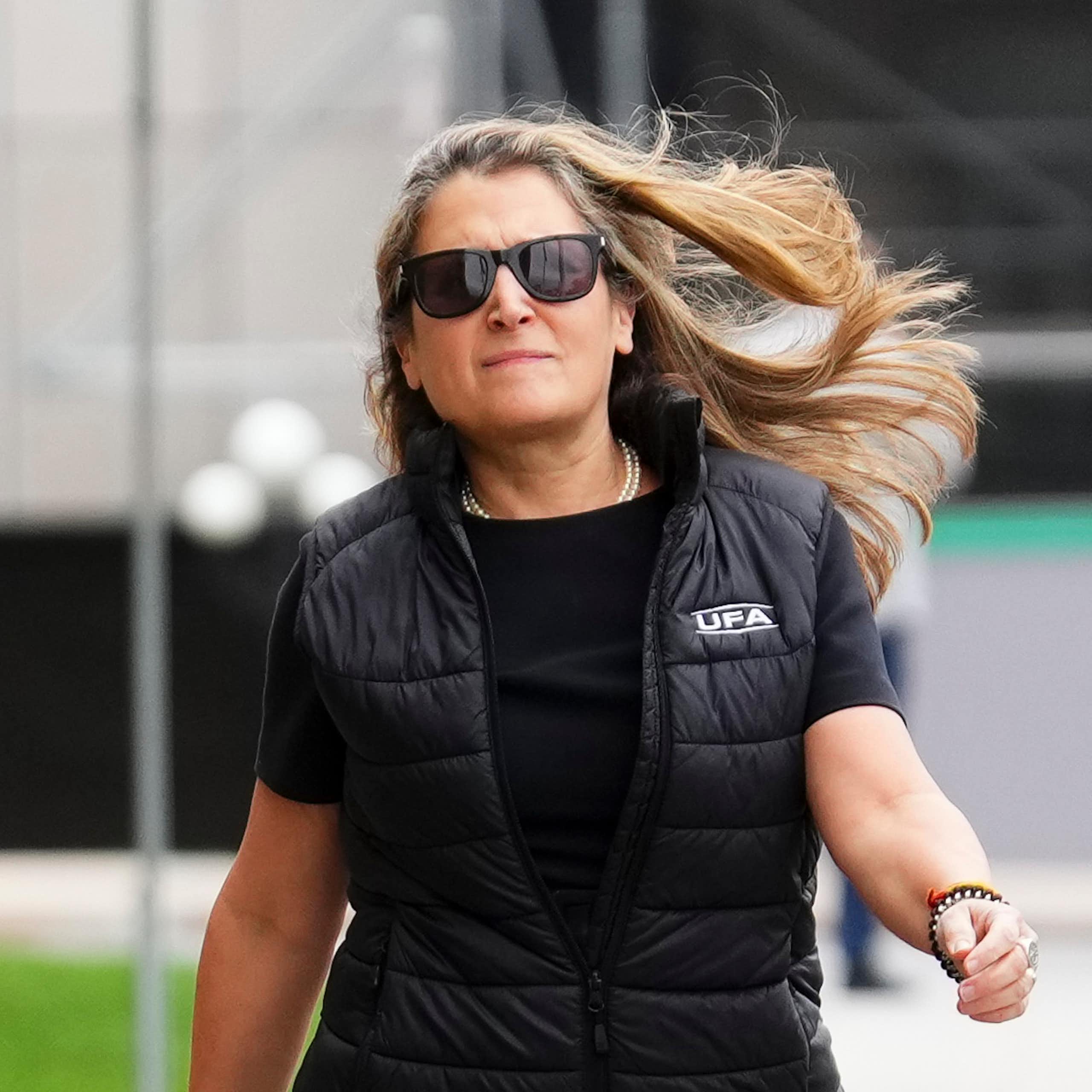 Une femme portant des lunettes marche d'un pas décidé