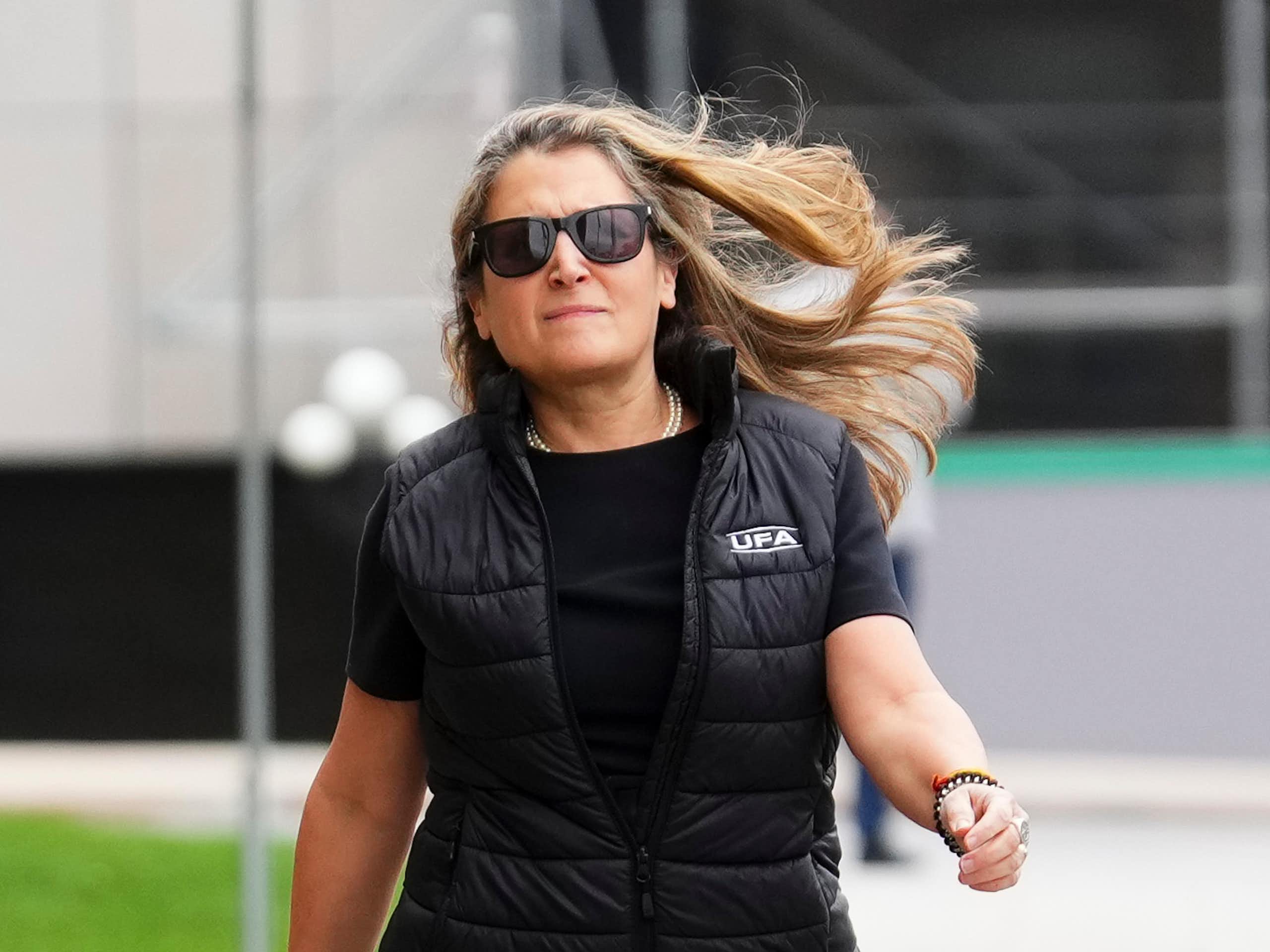 Une femme portant des lunettes marche d'un pas décidé