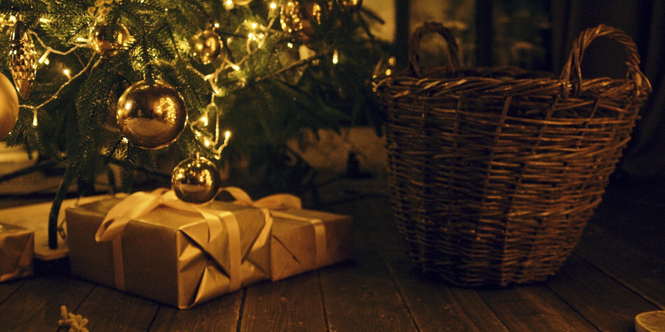 des cadeaux au pied d'un sapin de noël. la lumière est dorée.