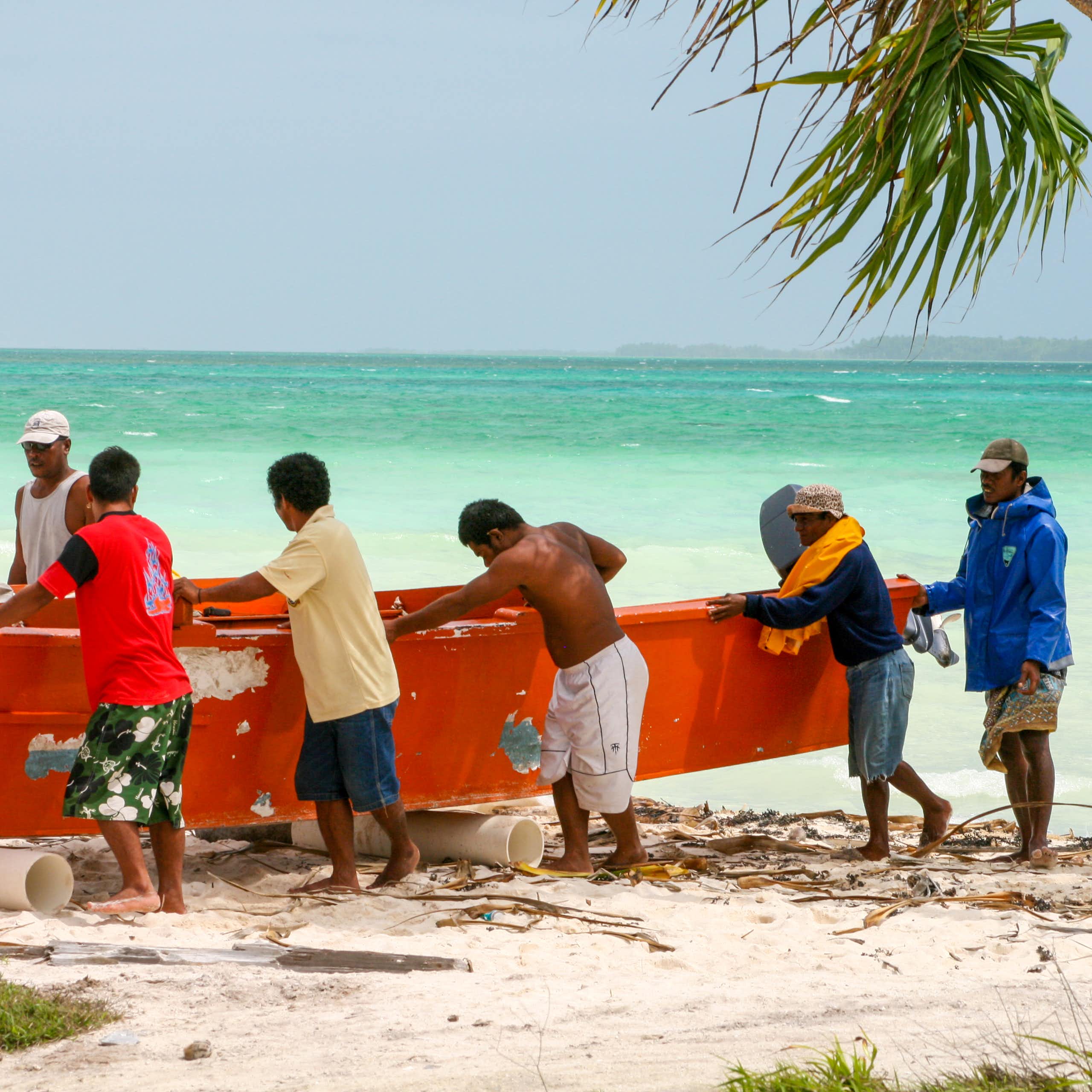 Men in Kiribati push a boat