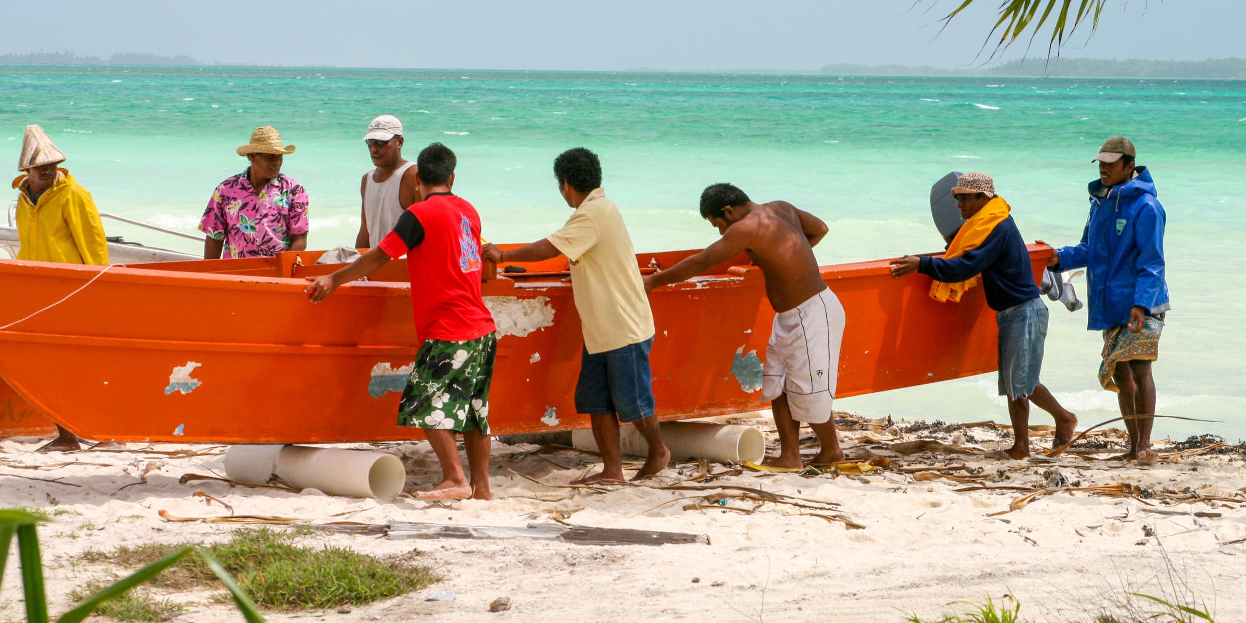 Men in Kiribati push a boat