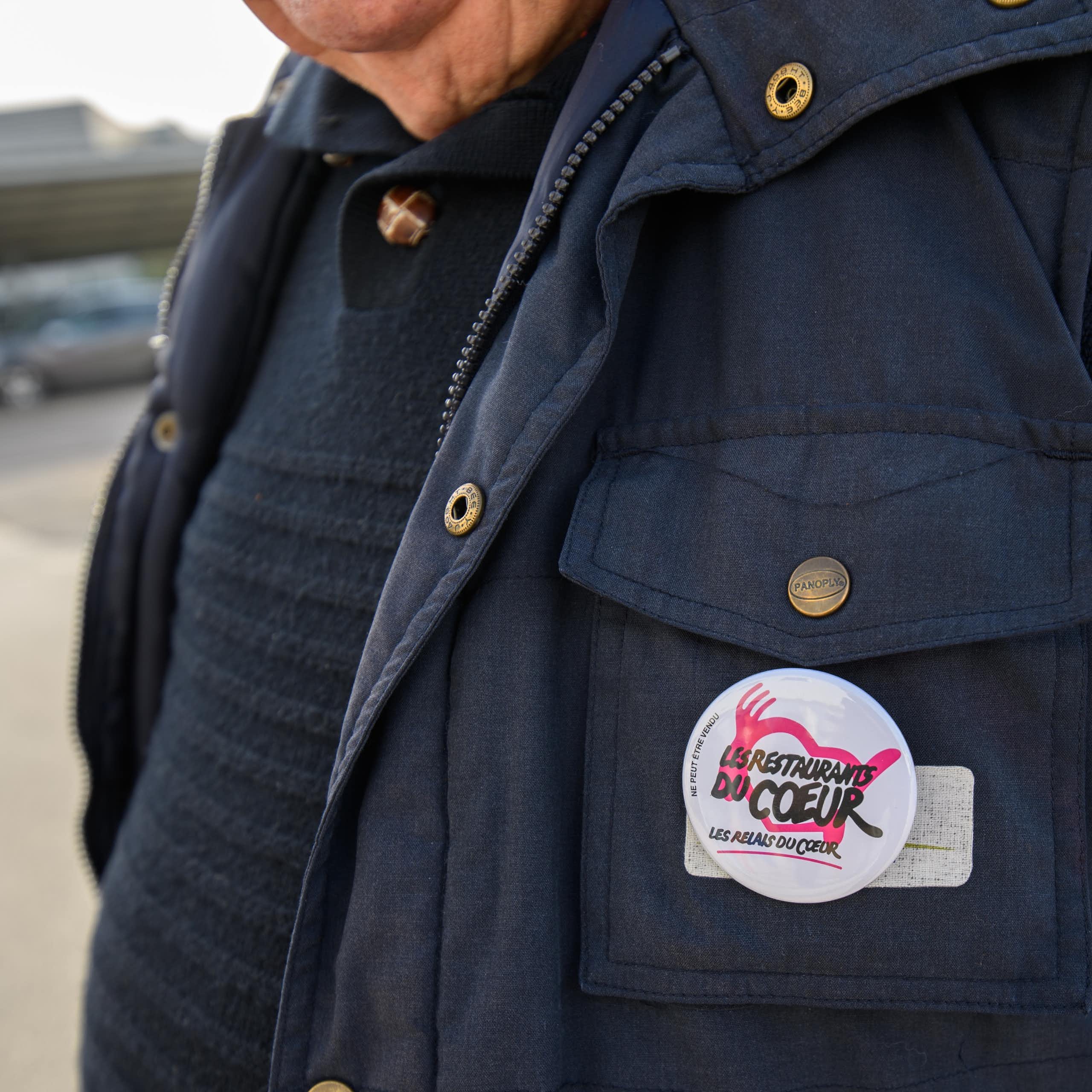 Un bénévole porte le logo des restaurants du coeur