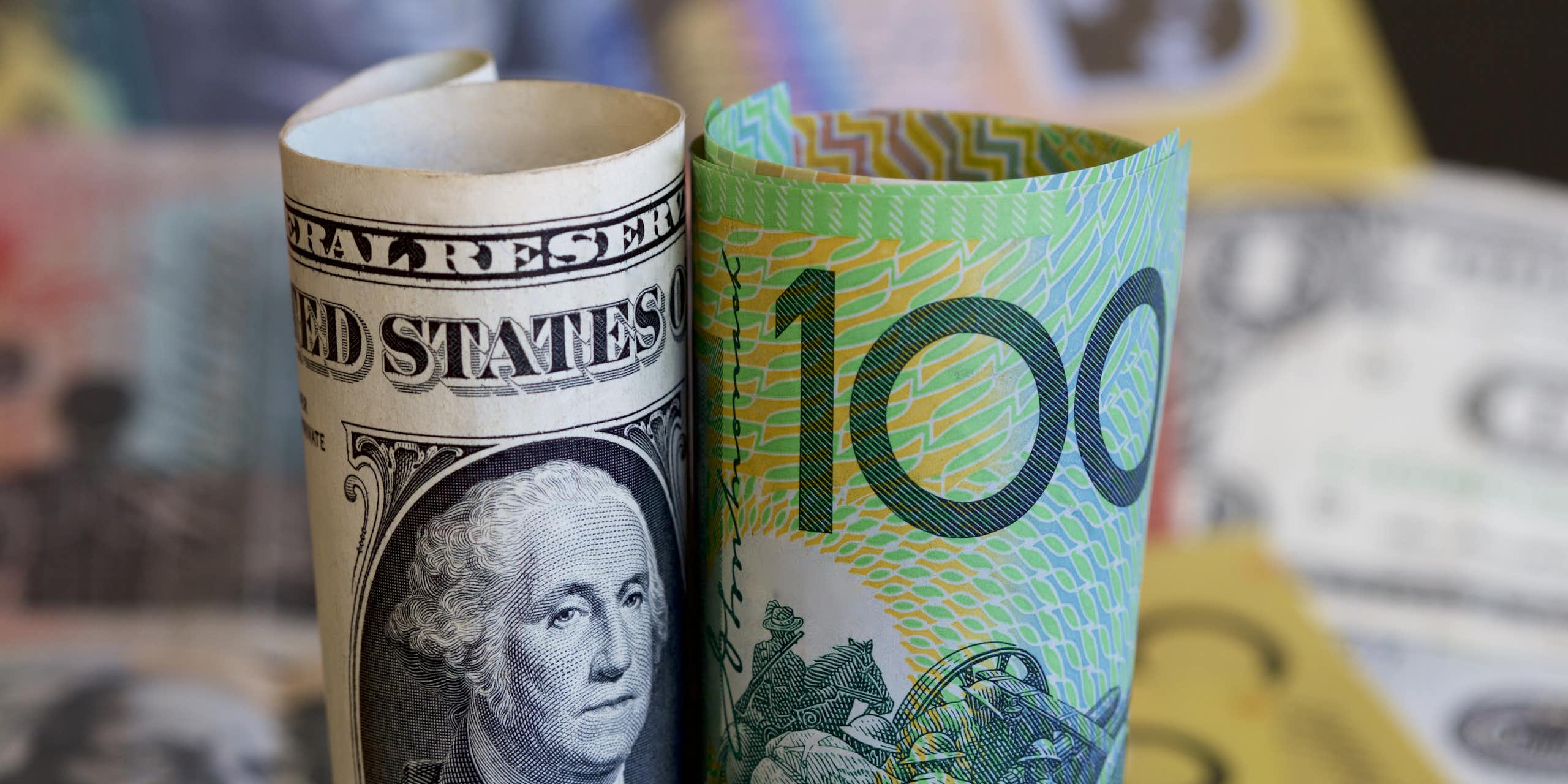 Rolled up Australian currency next to rolled up US currency