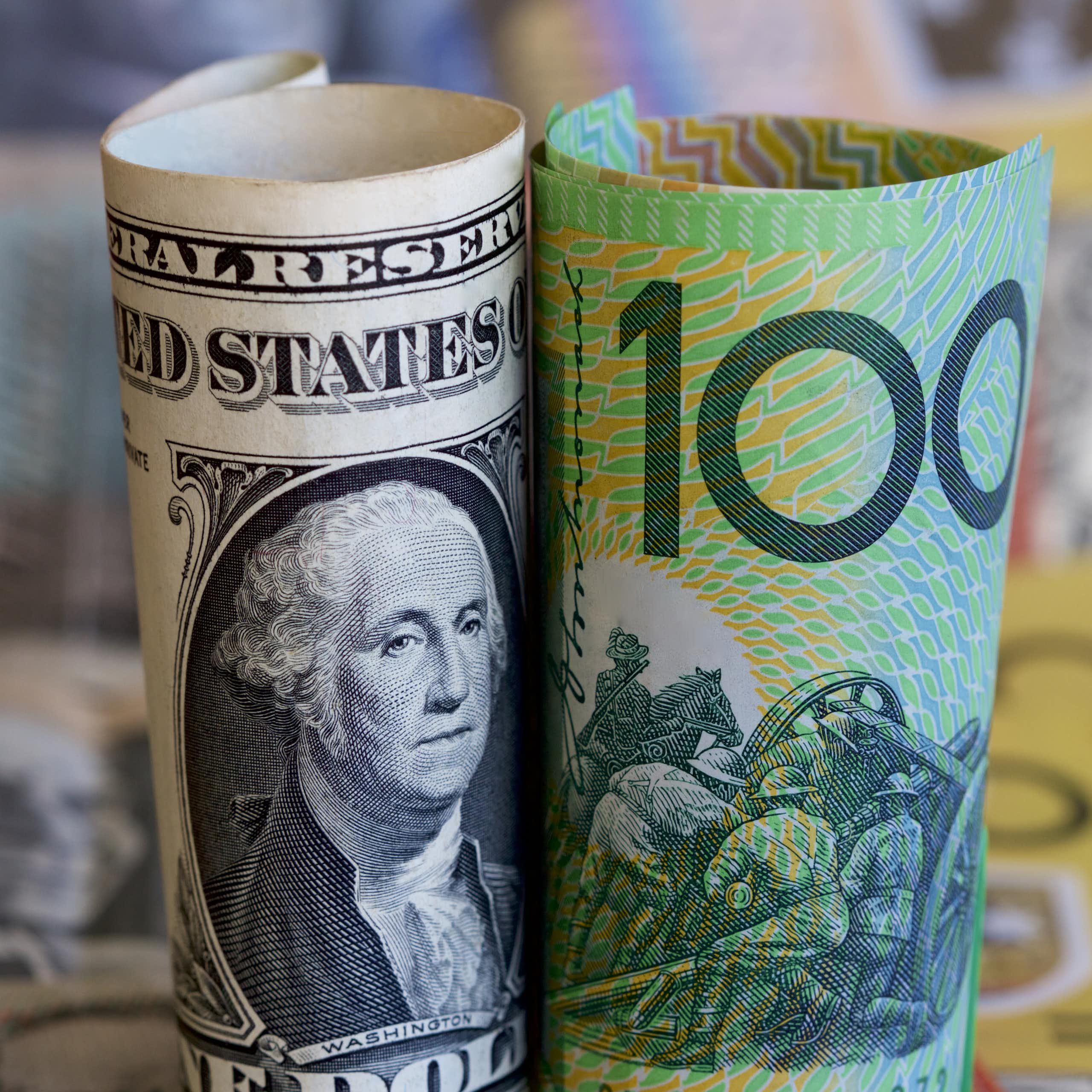 Rolled up Australian currency next to rolled up US currency