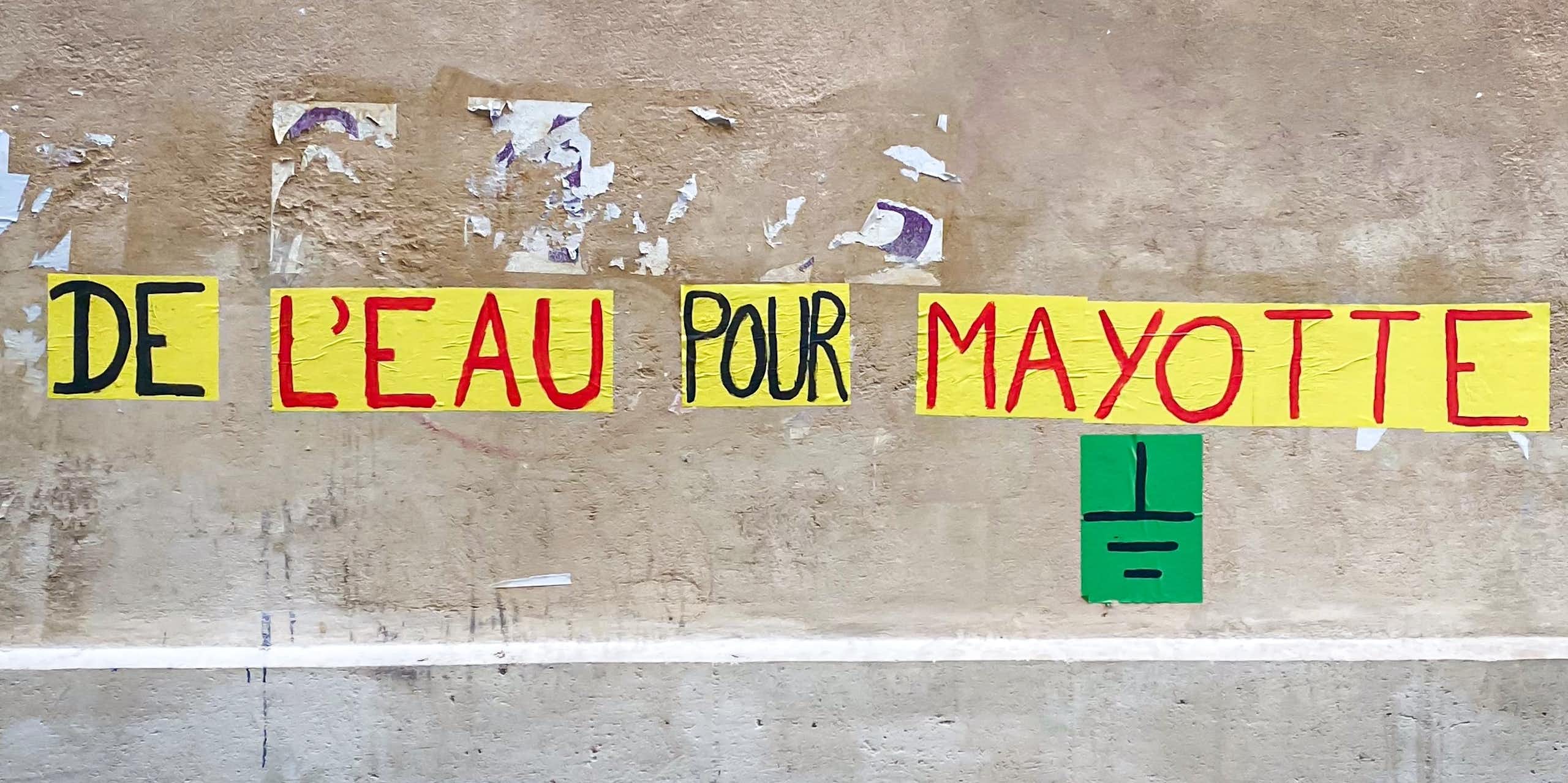 Affiche collée au mur avec écrit "de l'eau pour Mayotte"